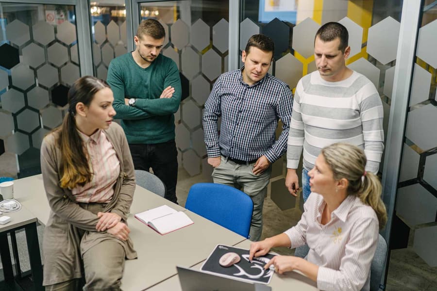 Colleagues helping each other at a desk