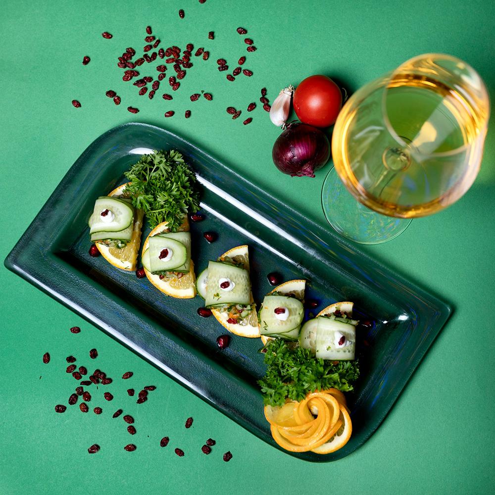 A plate of sides next to a glass of wine